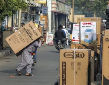 کراچی کی ایک مارکیٹ میں مزدور الیکٹرانکس کا سامان اٹھا رہا ہے