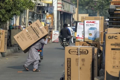 کراچی کی ایک مارکیٹ میں مزدور الیکٹرانکس کا سامان اٹھا رہا ہے